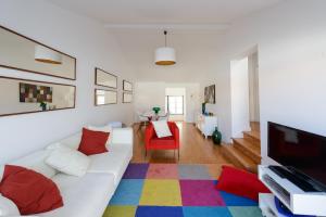 Timeless apartment at the heart of the village II في إيريسييرا: غرفة معيشة مع أريكة بيضاء وسجادة ملونة