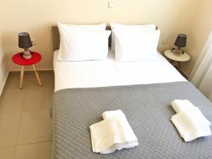 Agios OnoufriosにあるPretty Apartmentのベッドルーム1室(大型ベッド1台、タオル付)