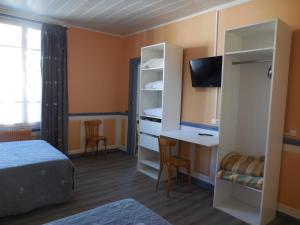 um quarto de hotel com uma cama e uma secretária e um quarto em Hotel de la gare em Cosne Cours sur Loire