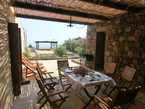 a patio with a table and chairs and a grill at comodissimo dammuso in Pantelleria