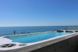 卢斯Casa do Mar - Luxurious Villa with Swim Spa & sea view的阳台的热水浴池,背景为大海