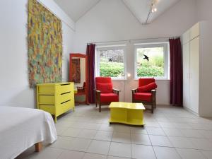 a bedroom with red and yellow chairs and a desk at Ferienhaus Ostseeblick in Kühlungsborn in Kühlungsborn