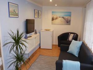 Una sala de estar con un sofá y un televisor. en Bungalow in Zweedorf mit Liegewiese, en Zweedorf