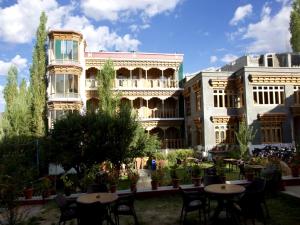 a group of tables and chairs in front of a building at Hotel Royal Palace - Leh in Leh