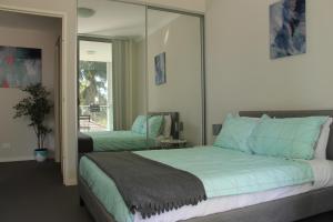 a bedroom with a large bed and a mirror at Enjoyable Holiday Home For Group Six in Waitara
