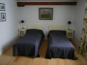 two beds in a room with two tables and two lamps at Moulin Saurele in Mont-Notre-Dame
