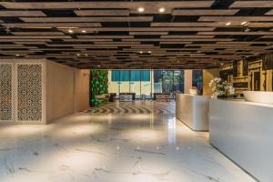 a lobby with a large room with wooden ceilings at Citrus Grande Hotel Pattaya by Compass Hospitality in Pattaya South