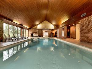 a large swimming pool with a wooden ceiling at Luxurious Villa with Private Pool in Durbuy in Grandhan