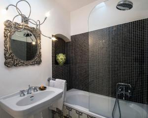 a bathroom with a sink and a tub and a mirror at Villa Lindo in Maiori