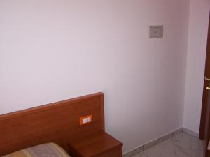 a bedroom with a bed and a white wall at Appartamenti Angelini in Riccione