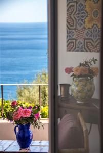a table with a vase of flowers and a window at Villa Lindo in Maiori +5 photos