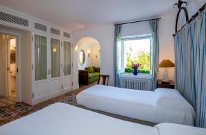 a hotel room with two beds and a window at Villa Lindo in Maiori