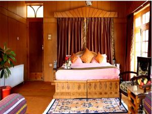 a bedroom with a large bed with a canopy at Hotel Royal Palace - Leh in Leh +21 photos
