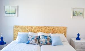 a bedroom with a white bed with blue pillows at Belém River Apartment in Lisbon