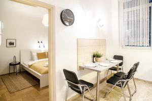 ブダペストにあるGarden Trees Apartmentのテーブル、椅子、ベッドが備わる客室です。