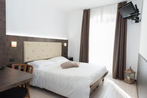 モーリにあるAlbergo Ristorante Da Neniのベッドルーム(ベッド1台、テーブル、テレビ付)