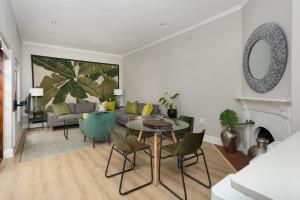 a living room with a table and chairs and a couch at Vesperdene Mews 2 in Cape Town