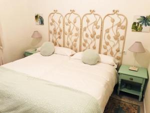 a bedroom with a white bed with two pillows at Casa Buleria in Jerez de la Frontera