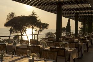 a restaurant with tables and chairs with a view of the ocean at Hotel Parentium Plava Laguna in Poreč