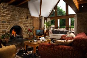 a living room with a brick fireplace and couches at Heath Farm Holiday Cottages in Swerford