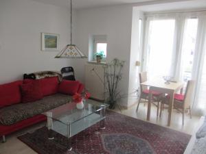a living room with a red couch and a table at Im Zentrum Katharinenstr. in Freiburg im Breisgau