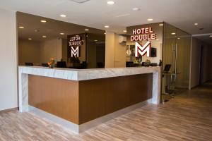 a hotel lobby with a reception desk and a hotel double sign at Double M Hotel @ Kl Sentral in Kuala Lumpur