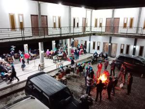 a group of people standing around a fire in a building at Bromo Backpacker Tosari in Pasuruan