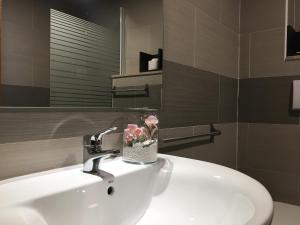 a bathroom with a sink with a vase of flowers on it at Hotel Corallo in Fregene