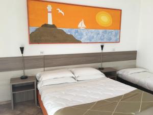 a bedroom with two beds and a painting on the wall at Hotel Corallo in Fregene