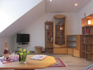 a living room with a table and a tv at Hotel Wolfsschlucht in Baden-Baden