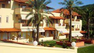 a view of the exterior of a hotel with palm trees at Kelyfos Hotel in Neos Marmaras