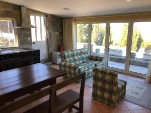 een woonkamer met een bank, een tafel en stoelen bij Quinta do Atoleiro in Lamego