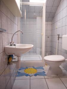 La salle de bains est pourvue d'un lavabo et de toilettes. dans l'établissement Apartments Susnja, à Vodice