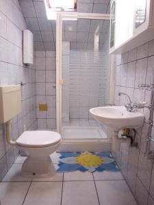 La salle de bains est pourvue de toilettes et d'un lavabo. dans l'établissement Apartments Susnja, à Vodice