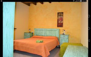 a bedroom with an orange bed and two night stands at Agricola Lanciani in Montefiore dellʼAso +65 photos