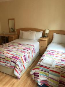 Duas camas sentadas uma ao lado da outra num quarto em Seven Dials Hotel em Londres