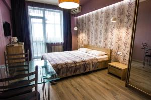 a bedroom with a bed and a glass table at Solo Apartment Dragomanova in Kyiv