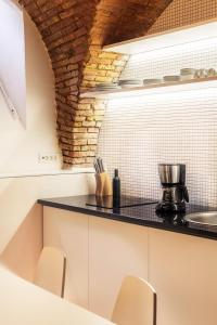 eine Küche mit weißen Schränken und einer schwarzen Arbeitsplatte in der Unterkunft Dungeon Apartment in Ljubljana