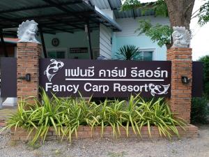 a sign for the entrance to a fancy camp resort at Fancy Carp Resort in Cha Am