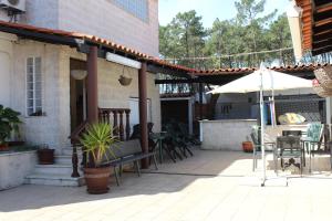 eine Außenterrasse mit einem Tisch und einem Sonnenschirm in der Unterkunft Hostel Casa Lucas in Charneca