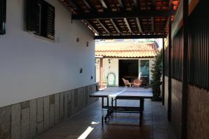 eine Terrasse mit einem Tisch in der Mitte eines Gebäudes in der Unterkunft Hostel Casa Lucas in Charneca