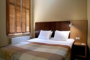 a bedroom with a large bed with white pillows at Hanza Hotel in Riga