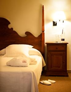 a bedroom with a bed with a wooden headboard and a table at Hotel Cala Sant Vicenç - Adults Only in Cala de Sant Vicenc