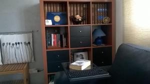 una estantería con un ordenador portátil en un escritorio en A casa con Stefania, en Settecamini