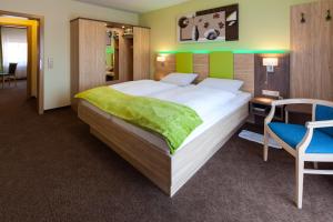a bedroom with a large bed and a desk and a chair at Landhotel Traube in Seewald