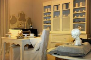 a bust of a girl sitting in a chair in a dining room at La Garçonniere-Suite in Salerno centro in Salerno