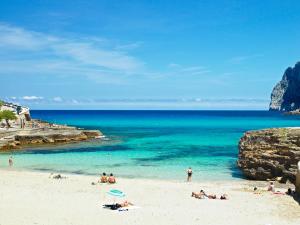 a group of people on a beach near the ocean at Hotel Cala Sant Vicenç - Adults Only in Cala de Sant Vicenc