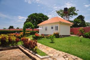 a small house in a yard with a garden at Victoria Lake View Guesthouse & Safaris in Entebbe