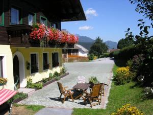 a patio with a table and chairs and flowers at Stögergut by Schladming-Appartements in Schladming