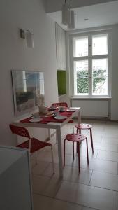una cocina con mesa blanca, sillas, mesa y ventanas en Apartament w Starej Kamienicy en Poznan